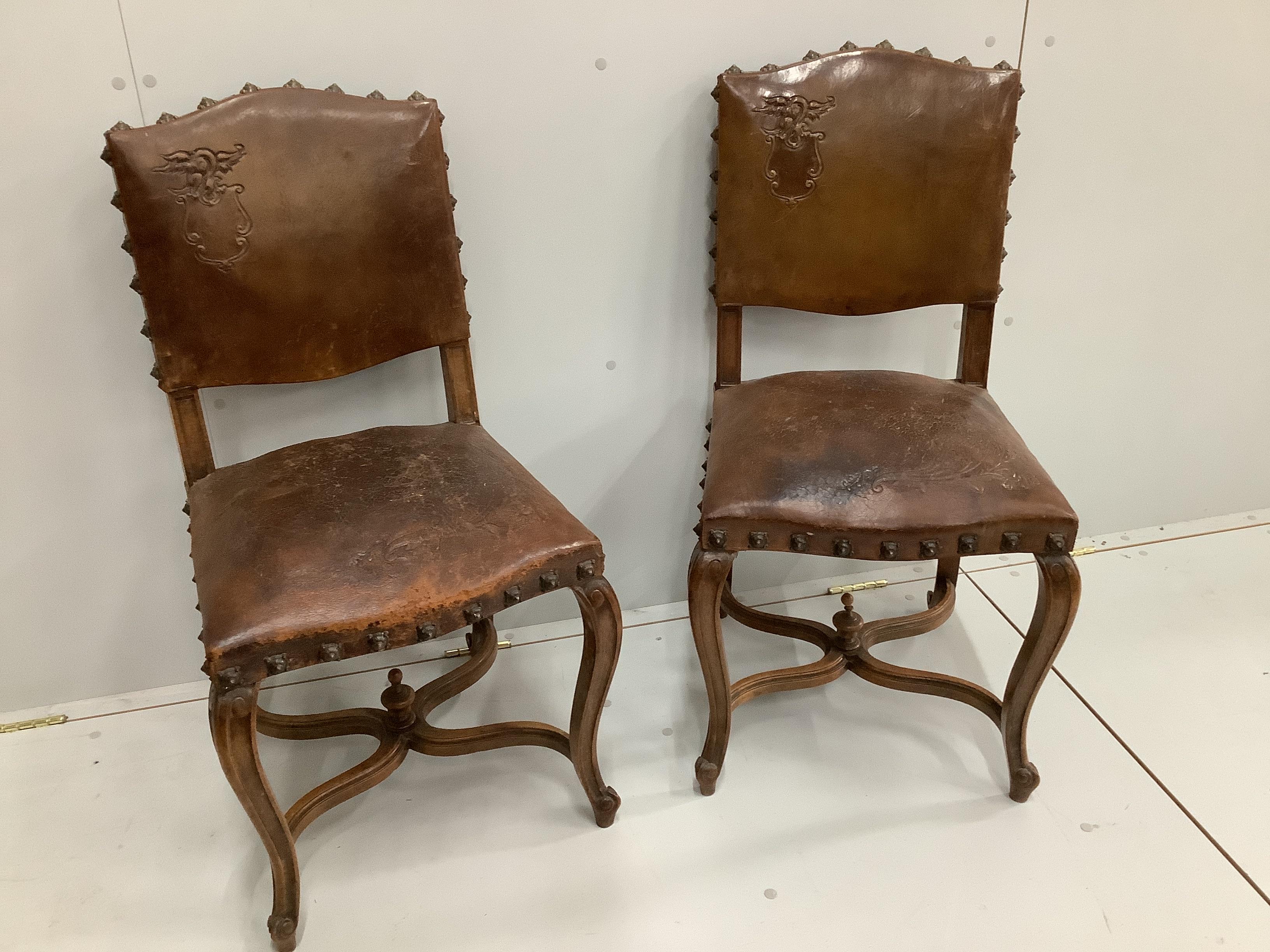 A pair of late 19th French Louis XV style carved oak dining chairs, with brown leather upholstery